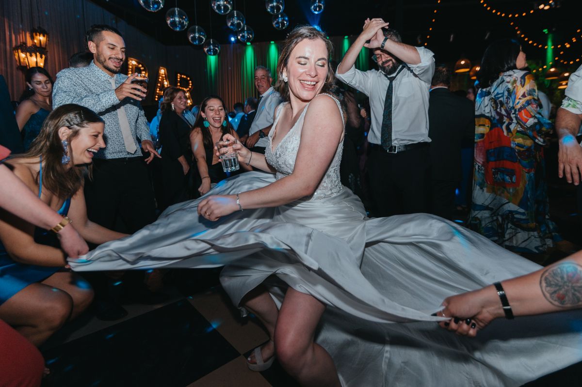 Bride dancing joyfully with wedding guests on a packed dance floor